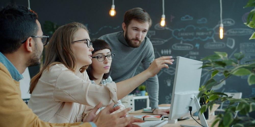 Product team collaborating around a computer